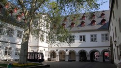 Blick von einem Innenhof auf ein historisches Gebäude mit einem Laubengang. Es ist das Koblenzer Rathaus.