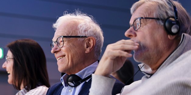 ©BAGSO_Lys Zwei Männer und eine Frau im Zuschauerraum. Ein Mann im vorderen Bereich des Fotos hat Kopfhörer an.