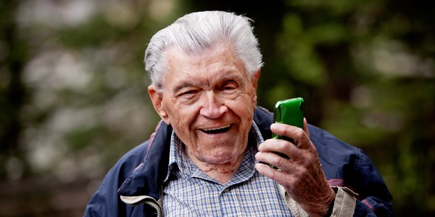 Aelterer Mann mit Smartphone in der Hand