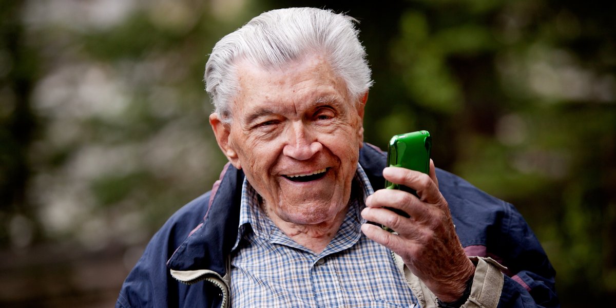 Aelterer Mann mit Smartphone in der Hand