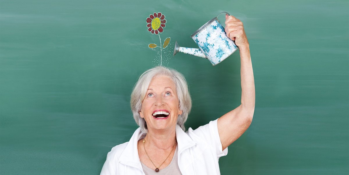 © contrastwerkstatt_adobe.stock.com Frau gießt mit einer kleinen Gießkanne eine Kunstblume auf ihrem Kopf