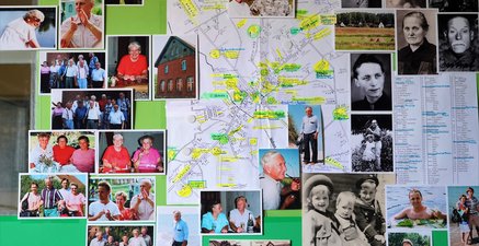 Im Zentrum ist der Ortsplan von Gertlauken im Jahr 1945. Darum gruppiert Fotos der Großeltern und deren Nachkommen.