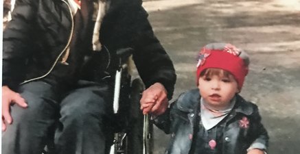 Rollstuhl (Uroma)!wird geschoben (Oma) und Enkelin fotografiert, Urenkelin wird an der Hand geführt 