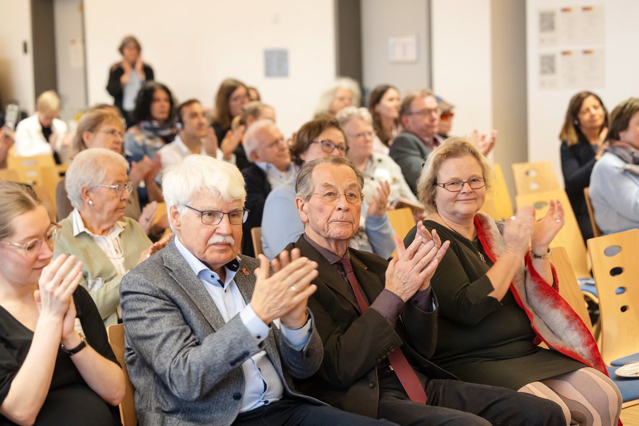 Teilnehmende der BAGSO-Fachtagung applaudieren. Zu erkennen sind Jens-Peter Kruse und Katrin Markus vom BAGSO-Vorstand, Franz Müntefering, der ehemalige BAGSO-Vorsitzende, und Nicole Zündorf-Hinte, Referentin im BMFSFJ.