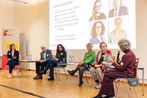 Six people are sitting on chairs on a stage and discussing. From left to right: Ina Voelcker, Jens-Peter Kruse, Friederike Scholz, Ilka Borr, Nicole Zündorf-Hinte and Dr Heidrun Mollenkopf.