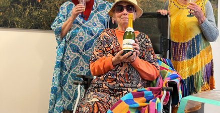 Drei ältere Frauen mit Sonnenbrillen vor einer Fototapete mit Bergmotiv