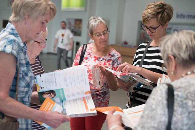 Visitors reading the programme of The German Senior Citizens‘ Day.