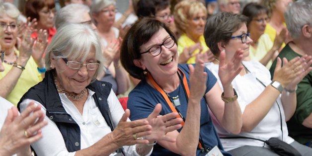 Frauen im Publikum klatschen lachend.