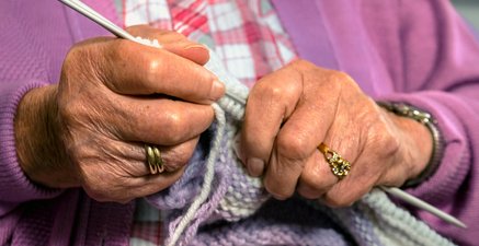 Nahaufname von strickenden Händen einer älteren Frau