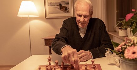 Schach Senior spielt mit Freude Schach