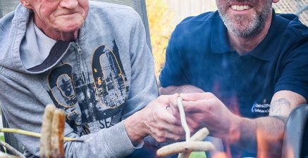 Bild zweier männlicher Personen beim Grillen.