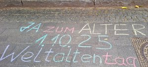 Auf dem Boden steht mit bunter Kreide geschrieben "JA zum Alter 1.1025 Weltaltentag."