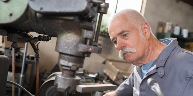 Älterer Mann in Maschinenbauwerkstatt