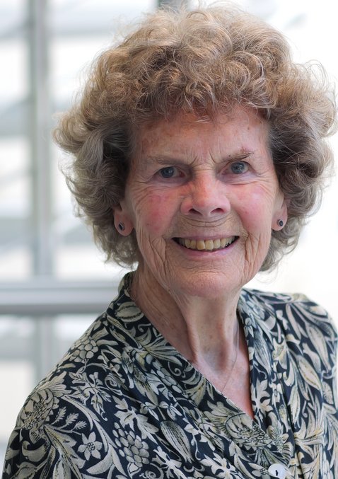 Dr. Heidrun Mollenkopf: Alte Frau mit kurzen braunen, gelockten Haaren. Sie trägt ein schwarz-weiß gemusterte Bluse.