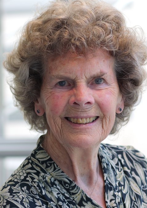 Dr. Heidrun Mollenkopf: Alte Frau mit kurzen braunen, gelockten Haaren. Sie trägt ein schwarz-weiß gemusterte Bluse.