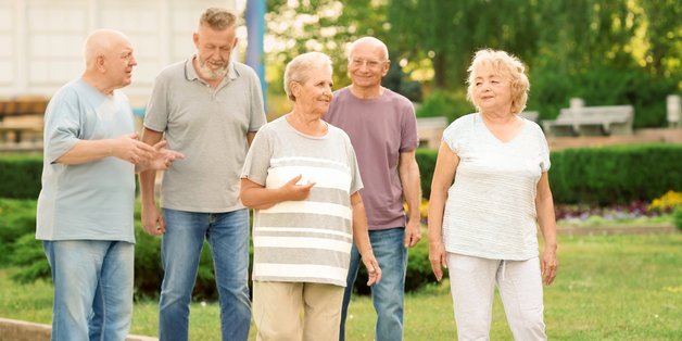 Gruppe älterer Menschen unterhalten sich im Laufen