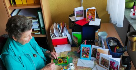 Eine Bewohnerin des Alten- und Pflegeheimes bastelt Glückwunschkarten. 