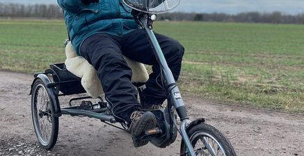 Warm angezogener älterer Mann auf einem Dreirad