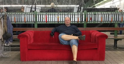 Älterer Mann sitzt auf einer roten Couch in der Kaue auf der Zeche Prosper 10 in Bottrop