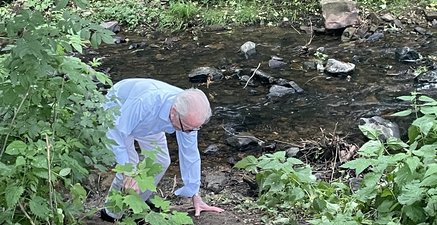 91-jähriger kraxelt auf allen vieren aus einem Bachbett zielstrebig eine steile Böschung hinauf.