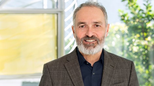 Protrait Dr. Guido Klumpp: Mann mittleren Alters mit Bart und Jacket.