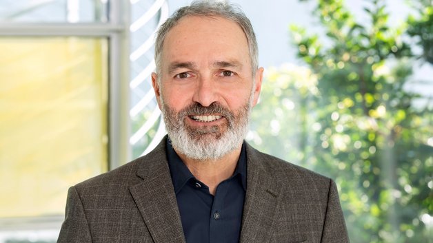 Protrait Dr. Guido Klumpp: Mann mittleren Alters mit Bart und Jacket.