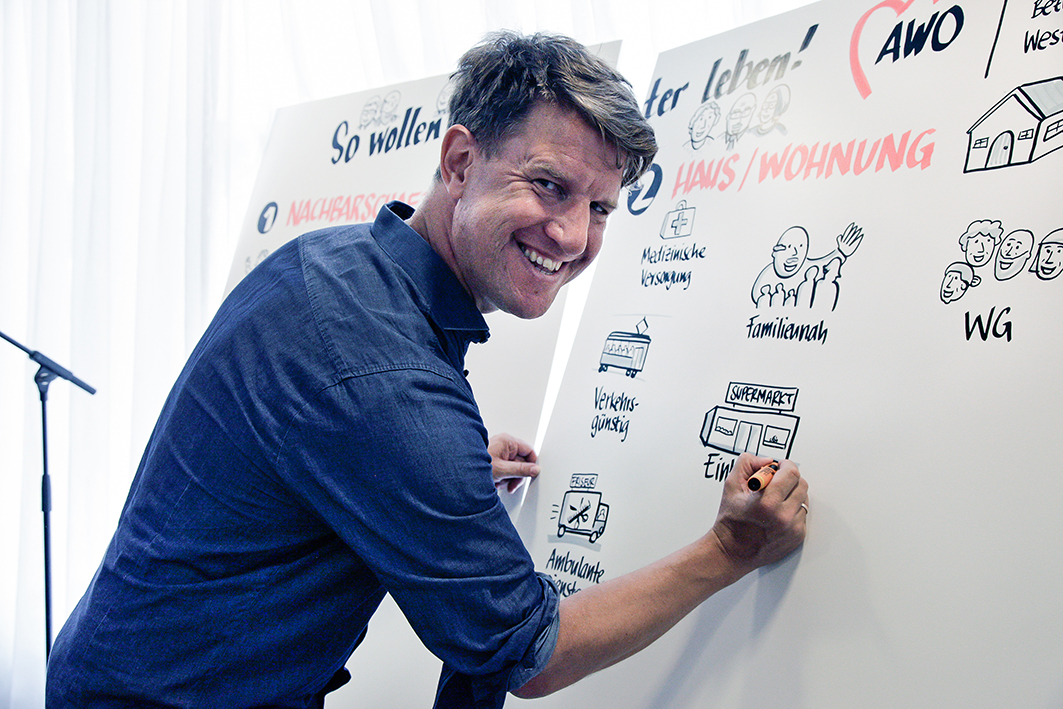 © BAGSO/ Kordestani A speaker producing flip chart drawings.